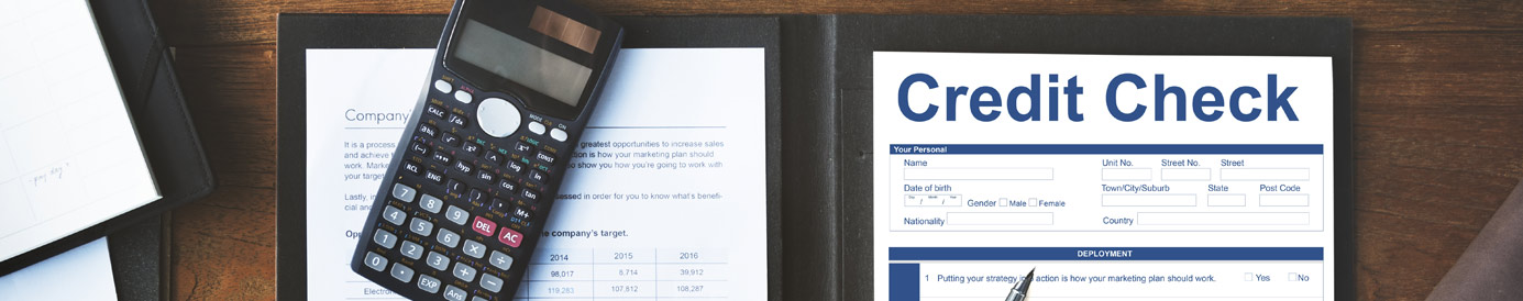 Overhead view of a table with a laptop, coffee, calculator and an open folder with a blank form that reads 