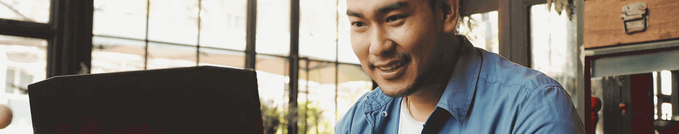 Man works happily on a laptop