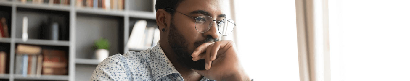 A man wearing glasses looking down