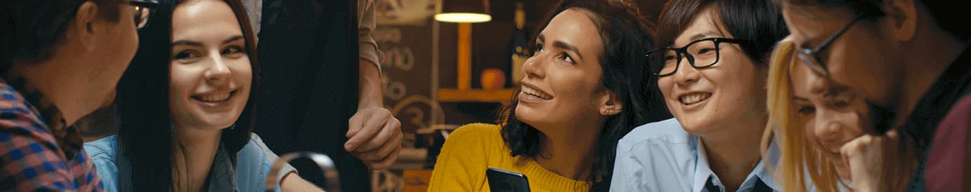 A group of seven people look at each other and smiling