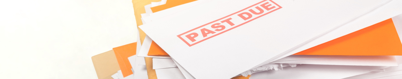 A stack of mail sits on a surface, some opened. On the top is a white envelope with the words “Past Due” stamped in red.