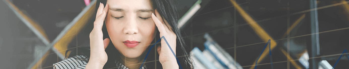 A woman using both hands to rub her temples
