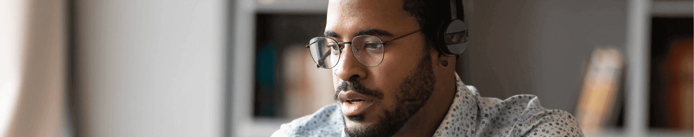 A man wearing glasses and a headset staring forward intently