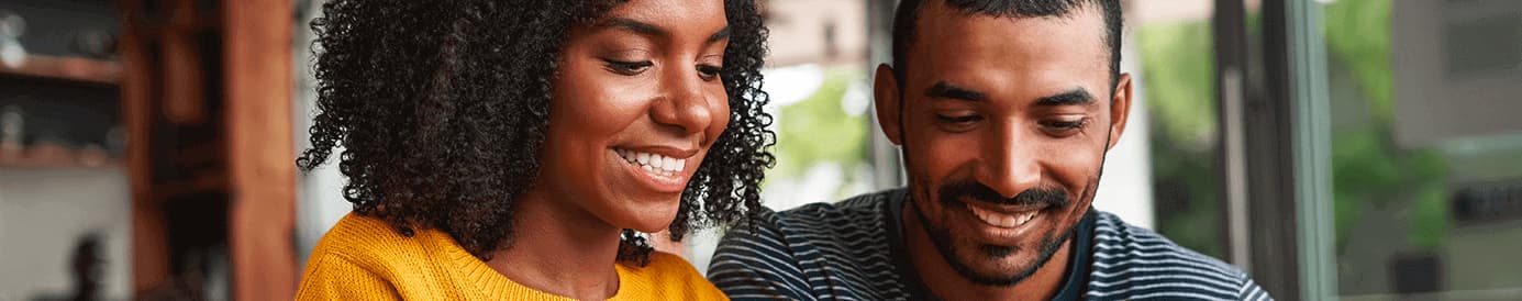 A woman and a man looking down and smiling