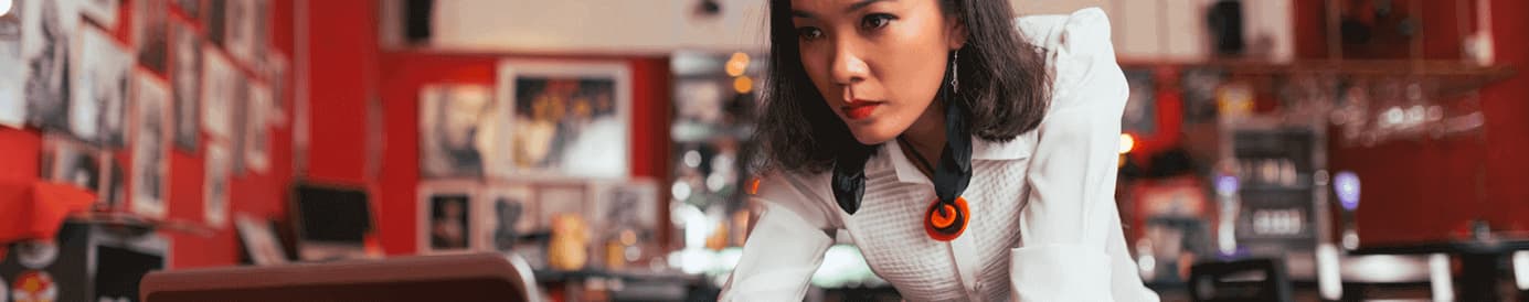 A woman focusing on her laptop screen and typing on her keyboard with her right hand