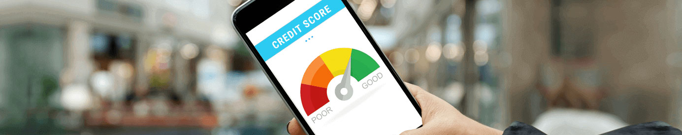 A person is holding a cellphone showing a guage for their credit score that indicates that their credit score is good