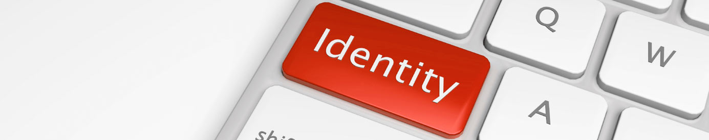 A red button with the word Identity written in white on a computer keyboard where the caps lock button would be