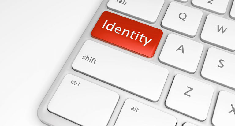 A red button with the word Identity written in white on a computer keyboard where the caps lock button would be