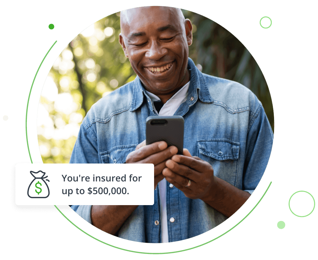 Man outdoors smiling while reading his cell phone