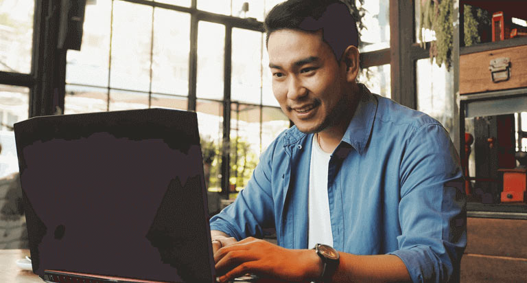 Man works happily on a laptop