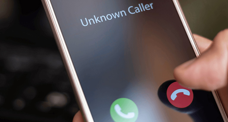 A person holding a cellphone with their right hand that is being called by an Unknown Caller