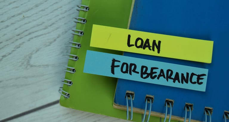 The word 'loan' is written on a yellow sticky tab, and the word 'forbearance' is written on a blue sticky tab. Both are attached to a stack of notebooks.