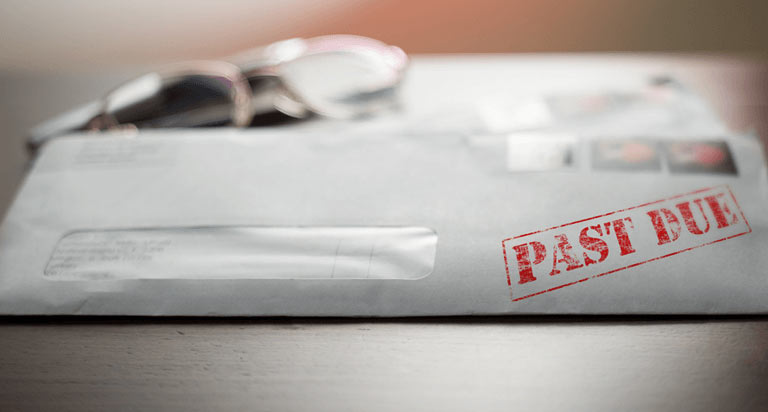 A white mailing envelope with the words PAST DUE stamped on it