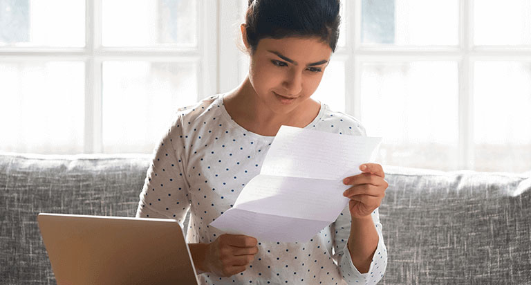 A woman holds a piece of paper with both hands and stares at it