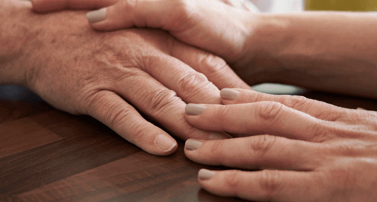 Two people touch their hands together