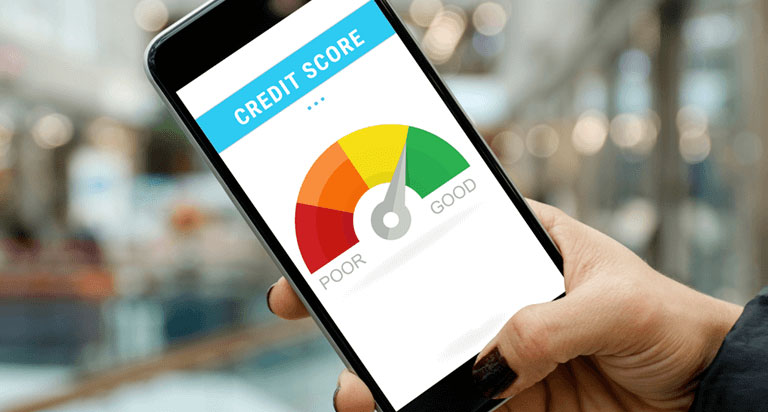 A person is holding a phone showing a guage for their credit score that indicates that their credit score is good