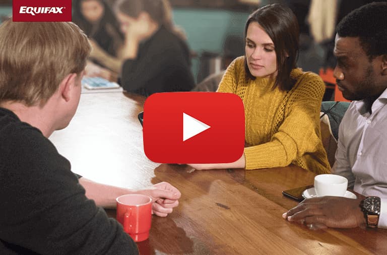 A group of three people focusing on a something on the woman's phone