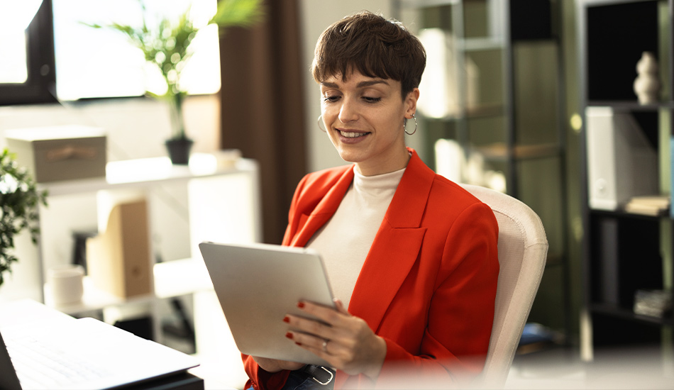 Mujer ejecutiva revisa información en su tableta desde su elegante oficina