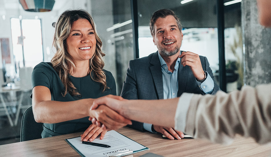 Mujer ejecutiva en apretón de manos tras recibir un contrato