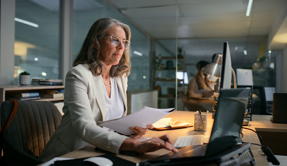 Mujer ejecutiva revisa documentos en su escritorio