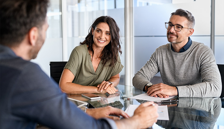 Pareja negocia un contrato de seguros con un empleado de la aseguradora