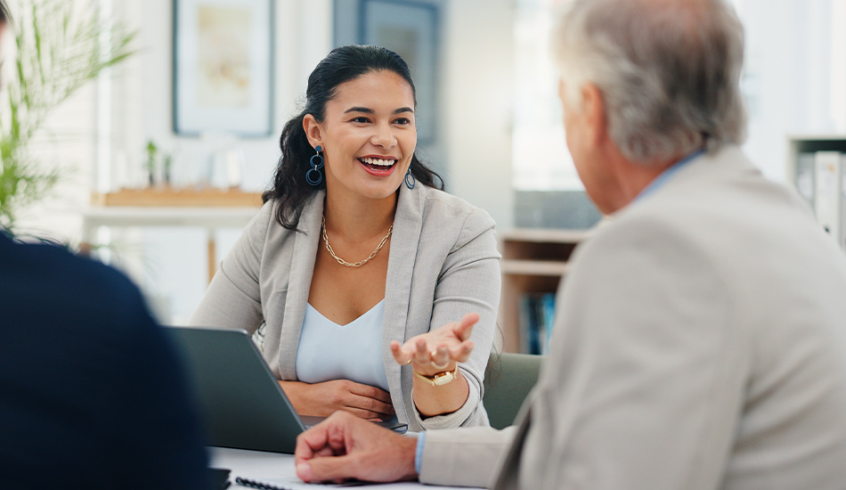 Mujer ejecutiva y adulto mayor conversan alegremente en el comedor de una casa