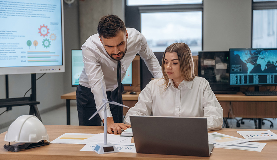 Dos trabajadores revisan información sobre su empresa de energía y comunicaciones