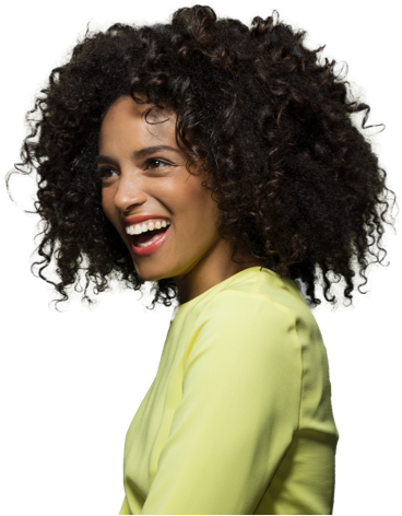 Woman with curly black hair looking to the left and smiling. She is wearing a long sleeved light green shirt.